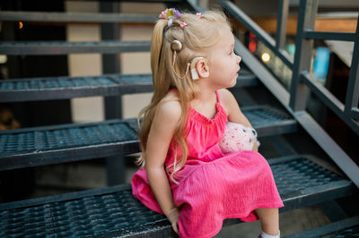 Rear view of young woman sitting on bench