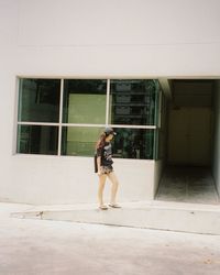 Full length of woman walking on building