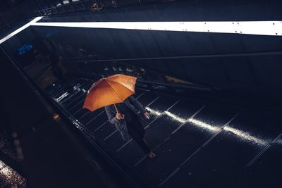 High angle view of woman walking with umbrella at subway