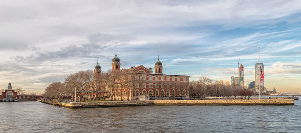 River by buildings against sky in city