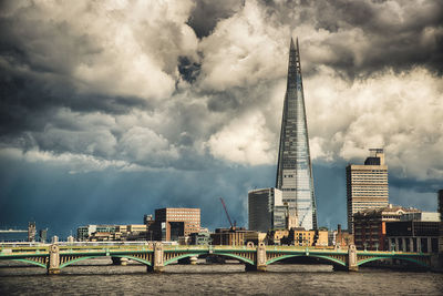 Southwark bridge over thames river against cloudy sky