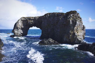 Rock formations by sea against sky