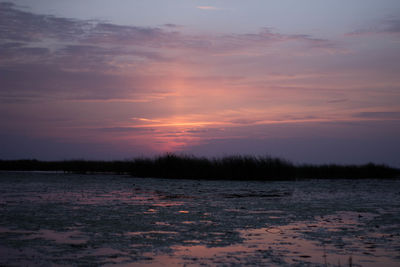 Scenic view of lake against orange sky