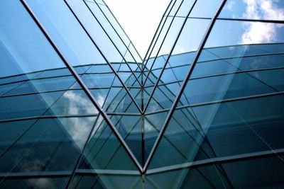 Low angle view of glass building against sky