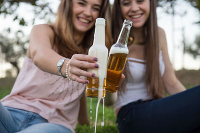 Happy friends toasting beer bottles