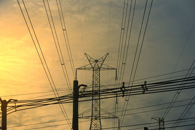 Low angle view of silhouette electricity pylon against sky during sunset