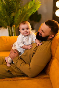 Portrait of boy sitting on sofa at home