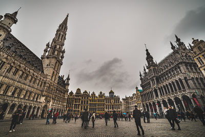 Group of people in historic building against sky