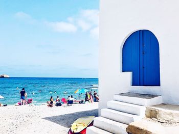 People at beach against blue sky