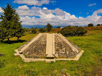 Panoramic view of old ruins on field against sky