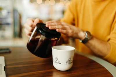 Midsection of coffee cup on table