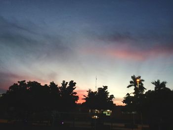 Low angle view of silhouette trees against sky