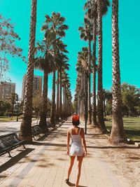 Full length rear view of woman walking on footpath