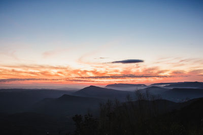 Scenic view of silhouette mountains against sky during sunset