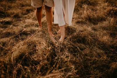 Low section of woman standing on grassy field