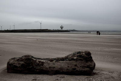 Scenic view of beach against cloudy sky