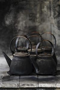 Close-up of rusty teapots on table