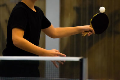 Midsection of man playing table tennis