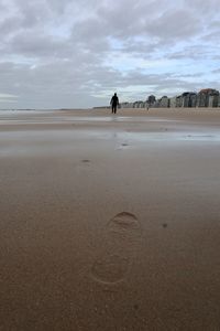 Man standing on beach against sky