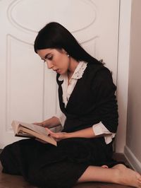 Side view of young woman using laptop at home