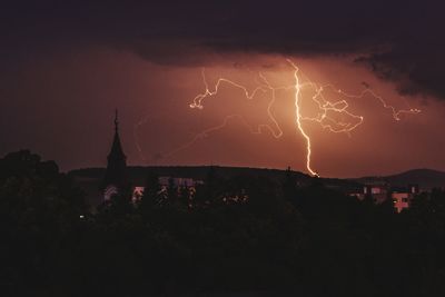Panoramic shot of illuminated cityscape against sky at night
