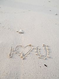 High angle view of heart shape with i love you text on beach