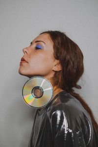 Side view of young woman against wall