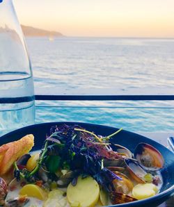 Close-up of drink on table against sea