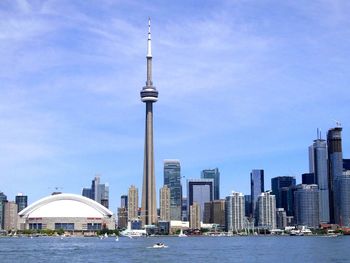 Cn tower by lake ontario against sky in city