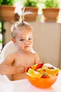 Girl sitting while eating fruit