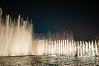 Fountain against sky at night