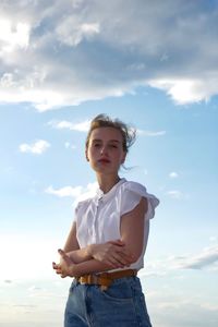 Portrait of teenage girl standing against sky