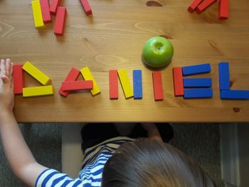 High angle view of child on wooden table