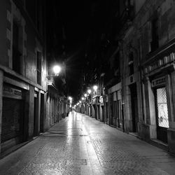 Walkway amidst illuminated street light at night