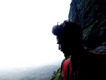 Portrait of man looking at mountain against sky