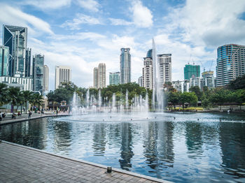 Swimming pool by lake against buildings in city