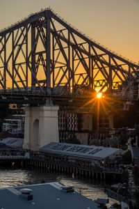 Illuminated bridge against sky at sunset