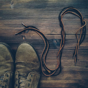 High angle view of shoes with lace on floorboard