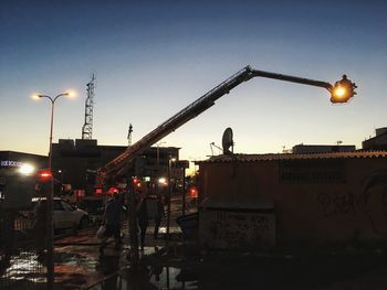 Illuminated street light against sky at night