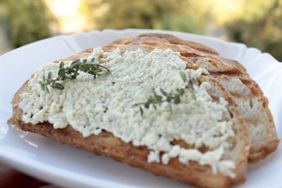 Sandwiches from a loaf and with cheese paste on a wooden stand and in a white plate