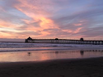 Pier over sea against sky during sunset