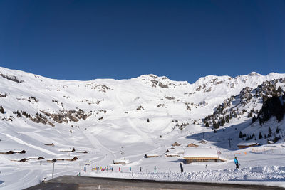 Scenic view of snowcapped mountains against clear blue sky