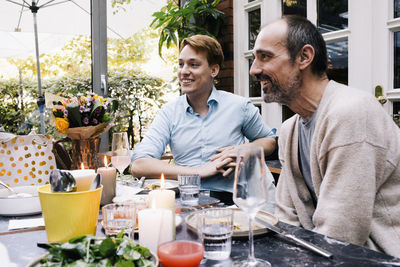 Happy parent sitting with son at restaurant during party