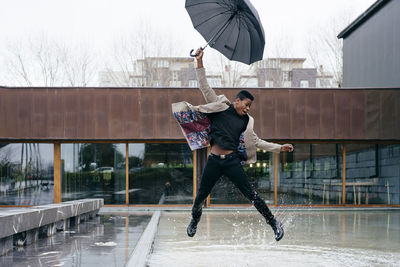 Full length of man jumping in rain