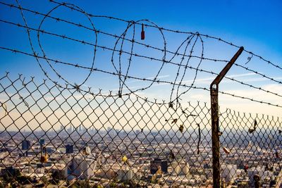 View of chainlink fence against sky seen through windshield