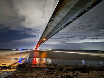 Bridge over river against sky at sunset