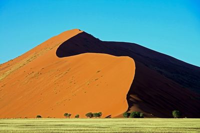 View of desert against clear blue sky