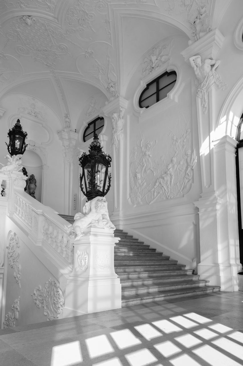 white, architecture, black and white, indoors, built structure, monochrome, monochrome photography, building, arch, architectural column, no people, lighting equipment, ceiling, black, religion, interior design, column, flooring, sunlight, the past, place of worship, history, staircase, pattern, ornate, belief, travel destinations, corridor, arcade, wealth, day, marble