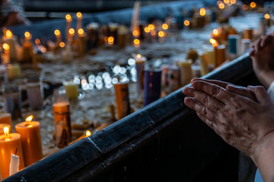 Midsection of person by illuminated temple against building