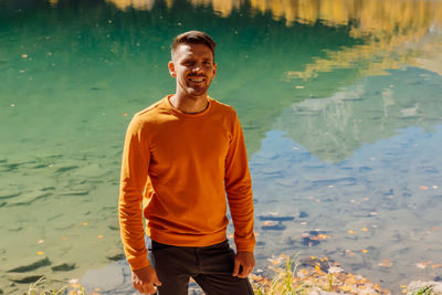 Portrait of young man standing in lake